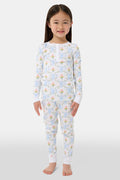 A child in Kids Floral Monkey Trellis Pajamas by Roller Rabbit sits barefoot on an adult’s lap outdoors. The adult, also barefoot and wearing light blue Pima Cotton sleepwear, hugs the child gently; only part of them is visible.