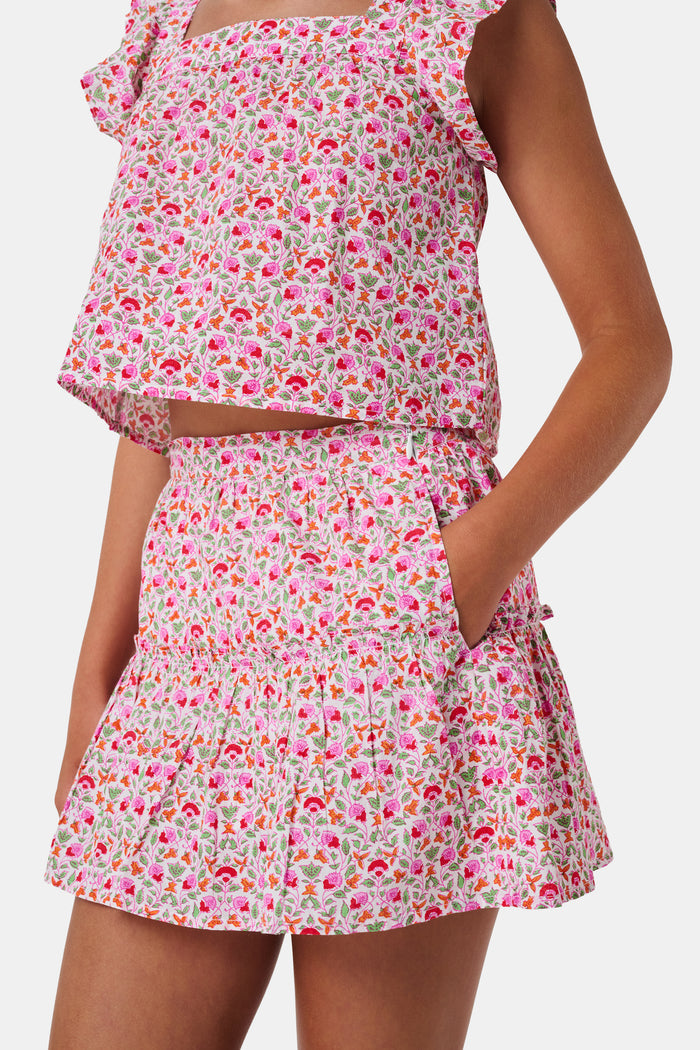 A Roller Rabbit Kids Garden Gate Floral Alexis Skirt with matching briefs, both showcasing a pink, green, and white flower pattern, is displayed on a plain white background. This cotton skirt is ideal for girls who love playful floral prints.