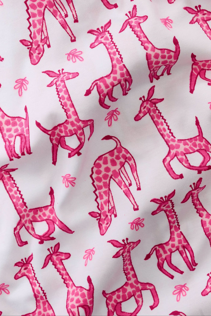 The Roller Rabbit Infant Gigi Giraffe Zipper Footie is a white Pima cotton baby pajama with long sleeves, footed legs, and a pink giraffe print. It features a convenient two-way zipper for easy changes.