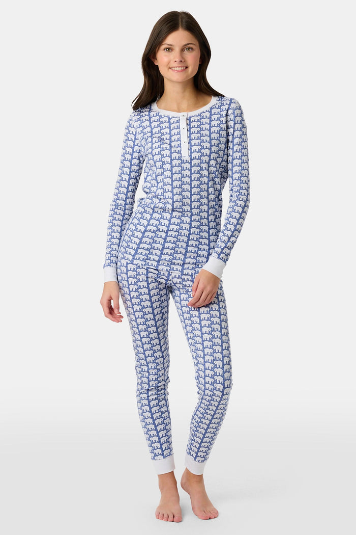 A young boy stands barefoot, smiling in Roller Rabbit Kids Hathi Pajamas—a matching Pima Cotton set with blue elephant print and white cuffs—against a plain white background.