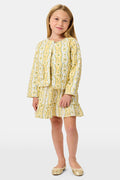 A young girl wearing a Roller Rabbit Kids Lillian Floral Stripe Finn Jacket paired with a matching ruffled skirt and gold ballet flats, standing and smiling against a plain white background—perfect for back-to-school style.