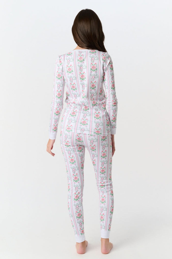 A young girl stands barefoot in Roller Rabbit Kids Monkey Block Stripe Pajamas—matching long-sleeve top and pants with playful monkey block stripes—smiling against a plain light gray background.