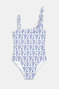 A girl wears the Roller Rabbit Kids Monkey Jacey One Piece with adjustable straps, standing under a palm tree, joyfully reaching for the clear blue sky while holding someone's hand.
