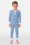 A young boy stands barefoot, smiling, and wearing Roller Rabbit Kids Monkey Pajamas—a matching top and bottom set. The background is plain white.