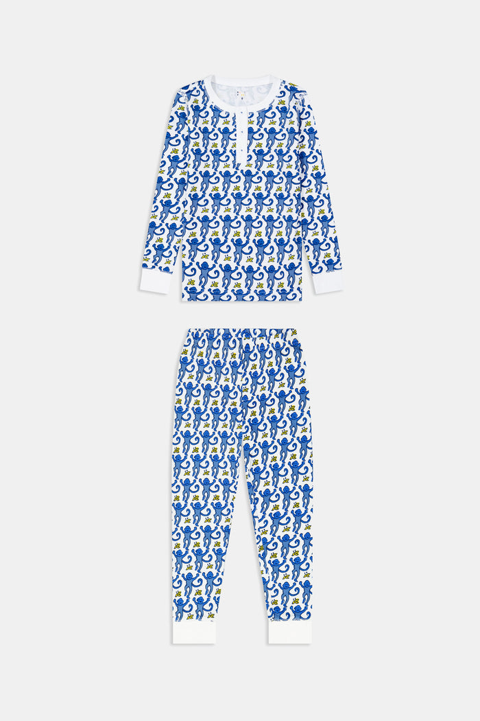 A young boy stands barefoot, smiling, and wearing Roller Rabbit Kids Monkey Pajamas—a matching top and bottom set. The background is plain white.