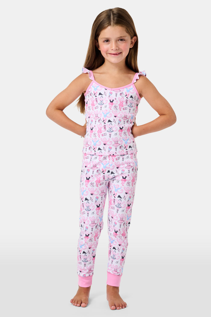 The Kids Monkey Pirouette Blaire Pajamas by Roller Rabbit is a children's pajama set crafted from soft Pima cotton, featuring a sleeveless top with ruffled straps and long pants, both in white with a playful pink, blue, and black monkey cartoon print and pink trim.