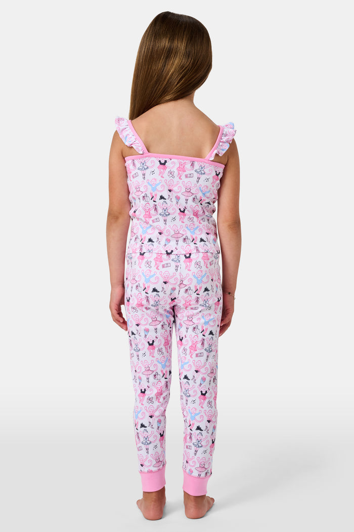 The Kids Monkey Pirouette Blaire Pajamas by Roller Rabbit is a children's pajama set crafted from soft Pima cotton, featuring a sleeveless top with ruffled straps and long pants, both in white with a playful pink, blue, and black monkey cartoon print and pink trim.