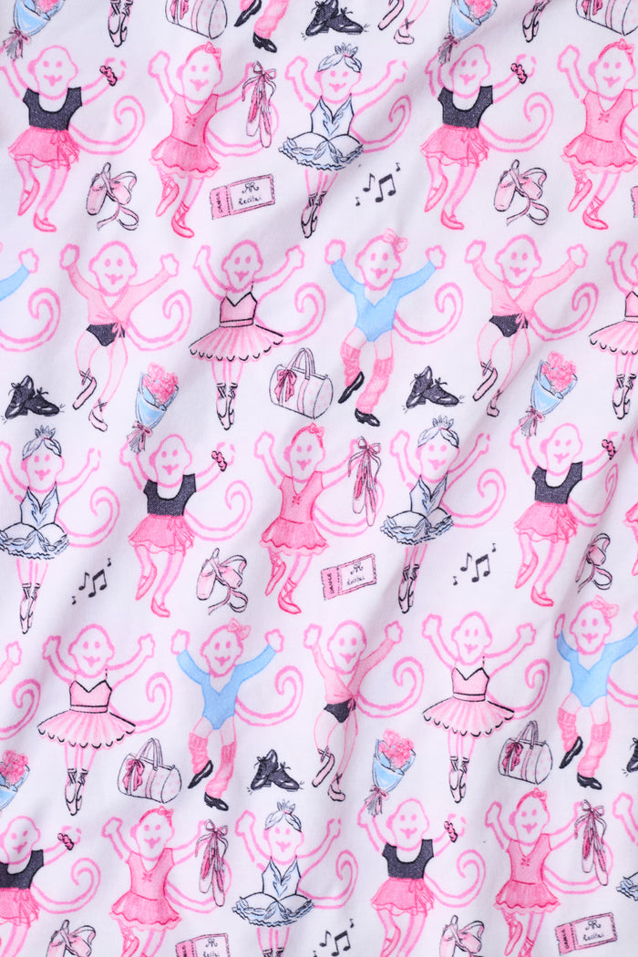 The Monkey Pirouette Polo Pajamas by Roller Rabbit feature a pink short-sleeve button-up top and matching shorts, adorned with a colorful and playful monkey, animal, and floral pattern on a white background.