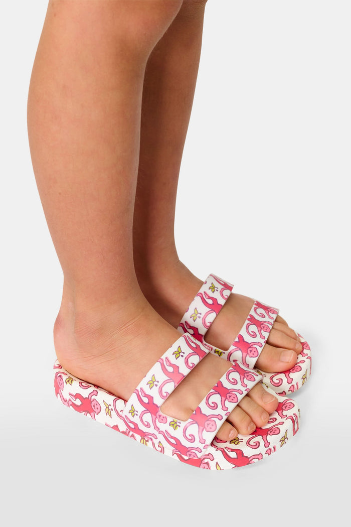 The Kids Monkey Pool Slides by Roller Rabbit feature playful pink and red swirls with abstract monkey prints on a white background, set against a plain white surface.