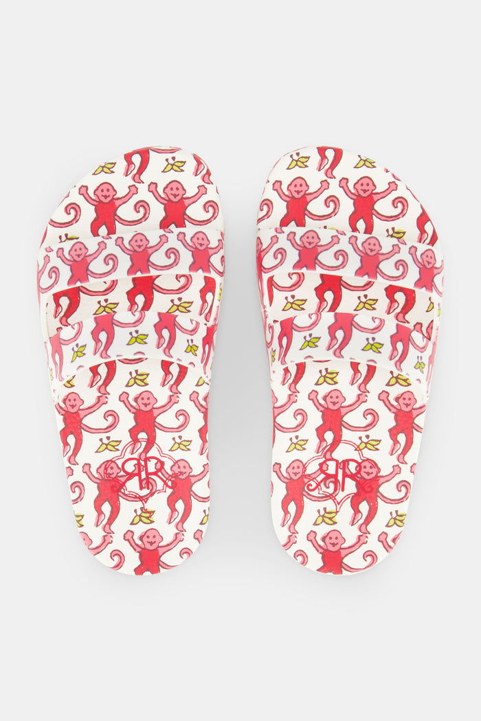 The Kids Monkey Pool Slides by Roller Rabbit feature playful pink and red swirls with abstract monkey prints on a white background, set against a plain white surface.