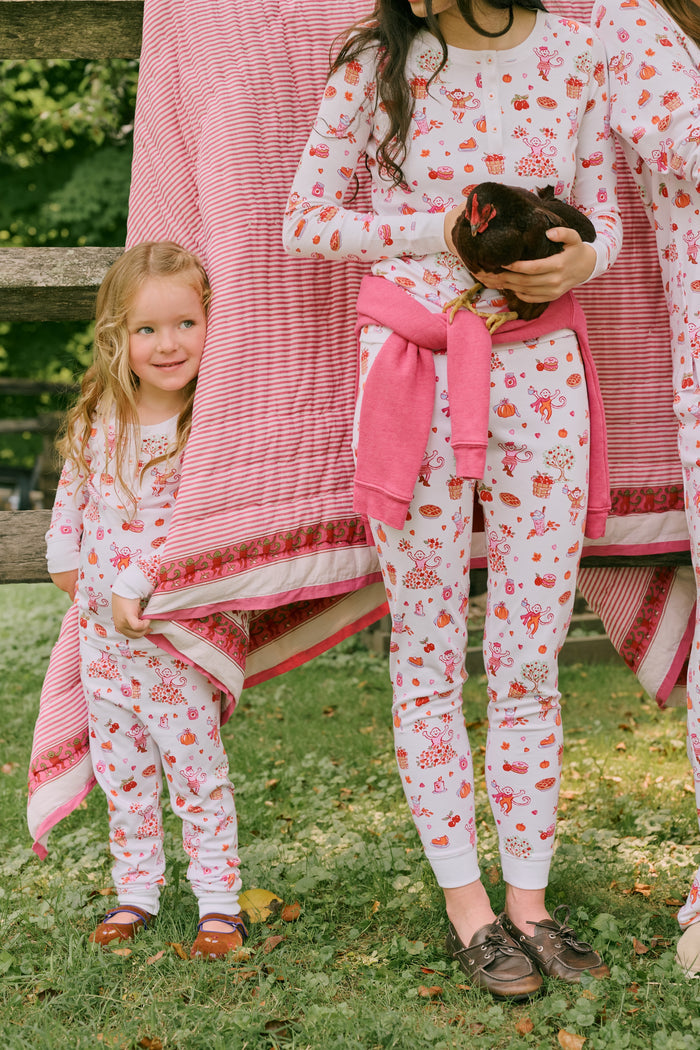 A girl wearing Roller Rabbit Kids Sweater Weather Pajamas stands barefoot, smiling, against a plain white background.