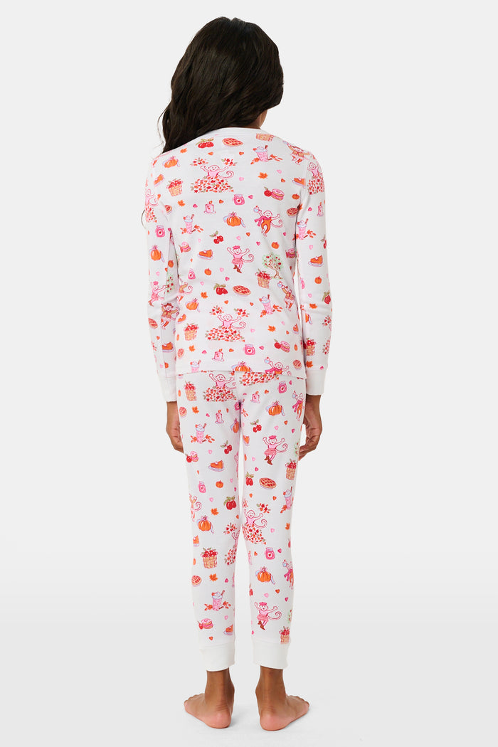 A girl wearing Roller Rabbit Kids Sweater Weather Pajamas stands barefoot, smiling, against a plain white background.