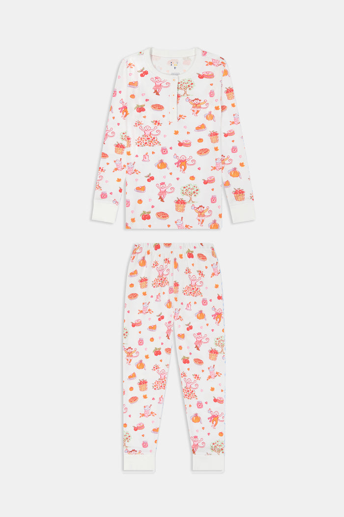 A girl wearing Roller Rabbit Kids Sweater Weather Pajamas stands barefoot, smiling, against a plain white background.
