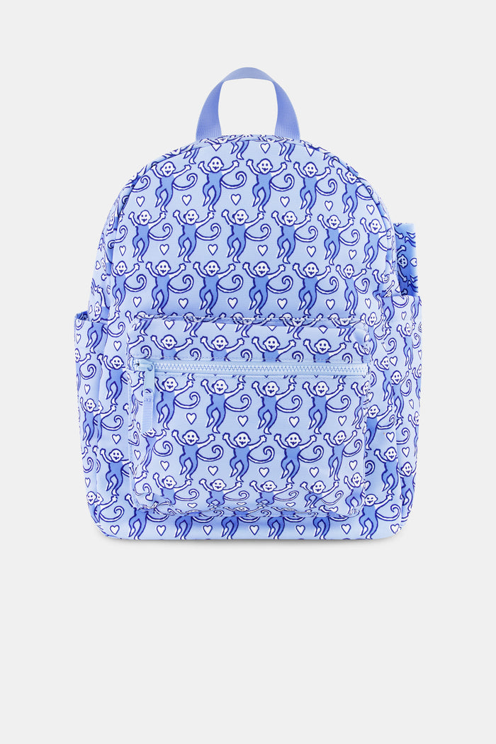 The Roller Rabbit Lovely Monkey Backpack for kids features a playful pattern of monkeys in various poses, a front pocket, and pink zippers set against a light background.