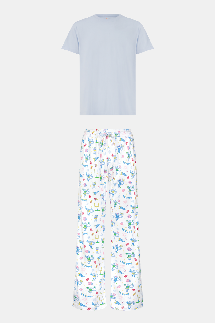 The Mens Game Day Troy Pajamas set by Roller Rabbit features a light blue short-sleeve t-shirt paired with white pajama pants decorated with colorful, playful cartoon animal and toy prints. The set is displayed on a plain white background.