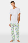 A person wearing Roller Rabbit Mens Game, Set, Monkey Troy Pajamas—white Pima Cotton pajama pants featuring a playful camp-themed print with tents, trees, and campfires—paired with a white T-shirt, standing barefoot against a plain background.