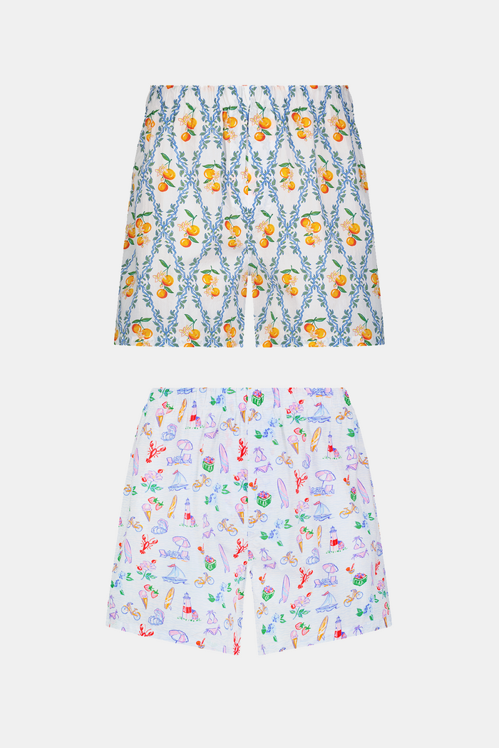 The Roller Rabbit Mens Summer Club/Clementine Trellis Boxer Set includes two soft cotton boxers: one with an orange fruit and branch print, the other with a vibrant beach scene featuring crabs, shells, and sandcastles for all-day comfort.