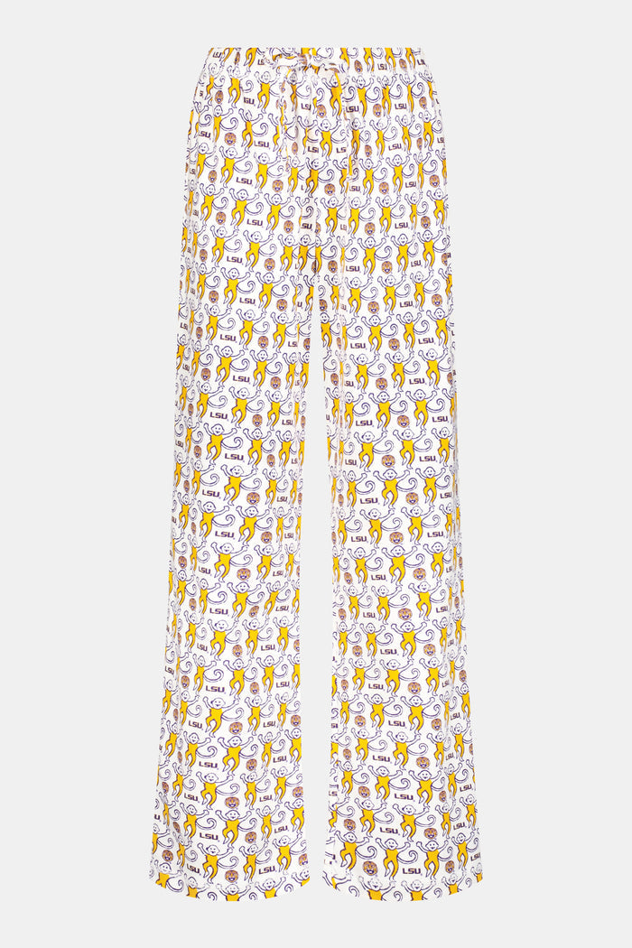 A man with short dark hair stands barefoot against a plain background, wearing a white t-shirt and Roller Rabbit Mens Tigers Lovely Monkey Simon Pant lounge pants with a yellow and brown design. He has a relaxed, neutral expression.
