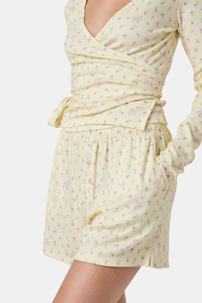 The Mini Monkey Blossom Brooklyn Boxer by Roller Rabbit features light yellow Pima cotton with a delicate pastel floral print and an elastic waistband. Displayed on a plain white background, these comfortable women’s loungewear sleep shorts are perfect for relaxing at home.