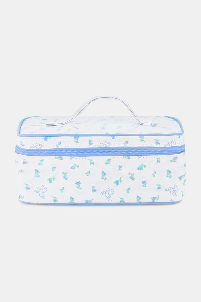 The Roller Rabbit Mini Monkey Blossom Carry All Case is a rectangular white fabric toiletry bag featuring a blue floral and monkey pattern, blue trim, a zip-around top closure, and a clear plastic handle on the lid.