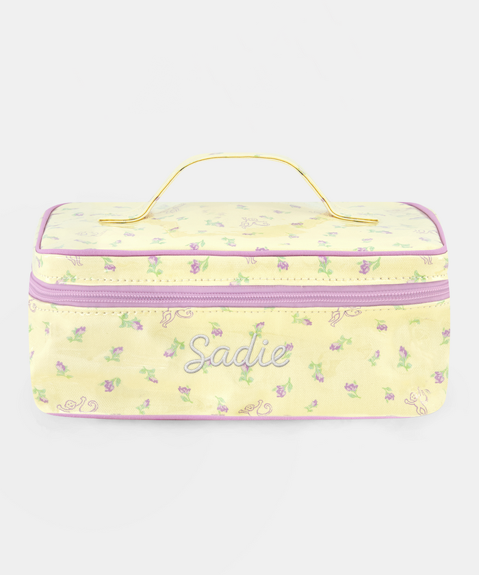 The Roller Rabbit Mini Monkey Blossom Carry All Case is a rectangular yellow toiletry bag featuring a pink floral pattern, a purple zipper, and a yellow handle on top. Displayed against a plain white background, this stylish travel bag is perfect for organizing your essentials.