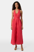 A woman with long curly hair wears the Roller Rabbit Monaco Geo Penelope Dress, a sleeveless, halter-neck, ankle-length red dress with subtle embroidery. She stands forward in open-toed, low-heeled sandals against a plain white background.