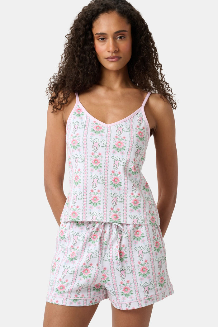 A woman with long curly hair wears the Roller Rabbit Monkey Block Stripe Mischa Set: a two-piece loungewear set featuring a matching camisole and shorts. She stands against a plain light background.
