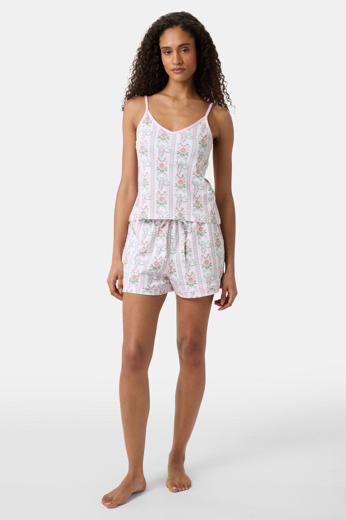 A woman with long curly hair wears the Roller Rabbit Monkey Block Stripe Mischa Set: a two-piece loungewear set featuring a matching camisole and shorts. She stands against a plain light background.