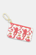 The Roller Rabbit Monkey Coin Pouch features water-resistant cotton canvas, a gold keychain clasp, red zipper, and playful pink monkeys with yellow bananas on a white background.