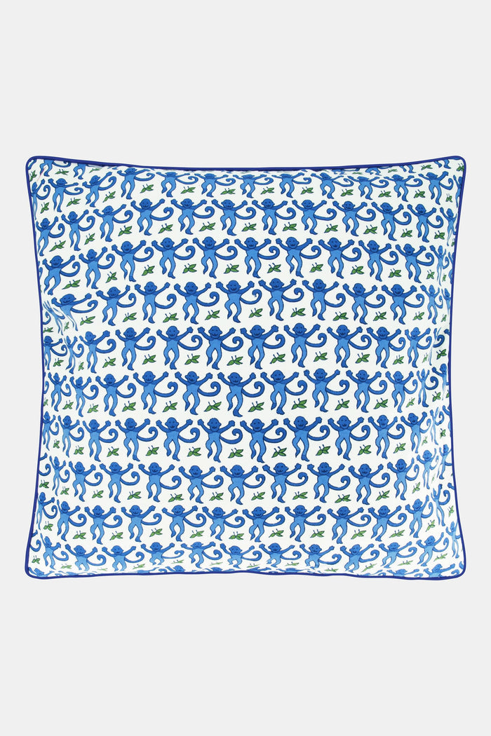 The Roller Rabbit Monkey Decorative Pillow features a white background with a repeating blue monkey and green leaf pattern, finished with a blue piped edge. This cotton pillow adds playful charm to any space.