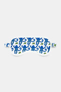 The Roller Rabbit Monkey Eye Mask is crafted from soft Pima cotton and features a white base with blue monkeys, small green bananas, and a matching strap.