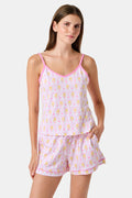 A woman wearing the Roller Rabbit Monkey Mischa Set stands with one hand in her pocket against a plain white background. This pajama set features a light pink flamingo print camisole and matching shorts, crafted from soft Pima cotton for comfort and style in women’s sleepwear.