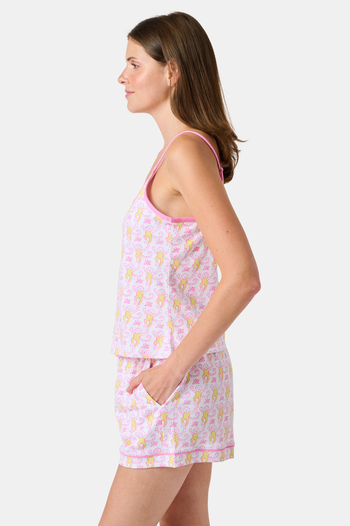 A woman wearing the Roller Rabbit Monkey Mischa Set stands with one hand in her pocket against a plain white background. This pajama set features a light pink flamingo print camisole and matching shorts, crafted from soft Pima cotton for comfort and style in women’s sleepwear.