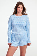 A woman with long brown hair wears the Roller Rabbit Monkey Rosebud Long Sleeve Baby Tee in light blue, featuring a subtle print, and matching shorts, while standing against a plain white background.