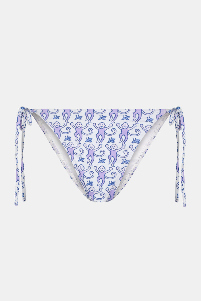 Wearing Roller Rabbit’s Monkey Serena Bikini Bottom with side ties and abstract blue shapes on white, made from UPF 50+ fabric for sun protection.