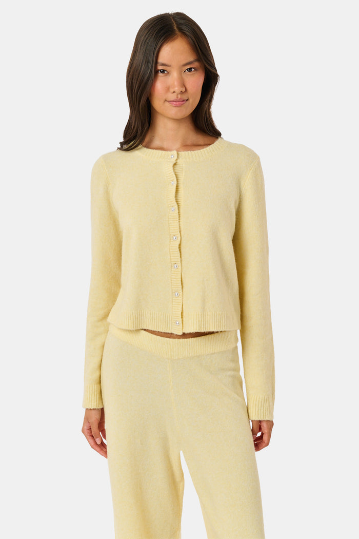 A woman wearing the Roller Rabbit Moxie Cardigan in butter yellow with matching pants, standing against a plain white background.