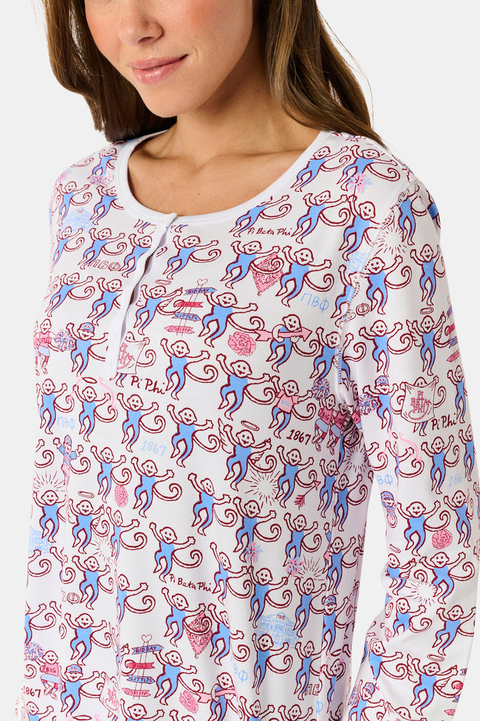 The Roller Rabbit Pi Beta Phi Monkey Pajamas are a long-sleeve set featuring a Henley top and pants, both adorned with a repeating red and blue monkey print on a white background. Made from soft Pima cotton, these pajamas are lightweight and comfortable.