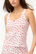 A woman wears the Picante Astor Tank by Roller Rabbit, featuring a scoop neck and red pepper print. Her brown hair is loose and her face partly out of frame. The look is casual and summery.