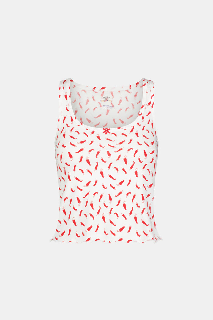 A woman wears the Picante Astor Tank by Roller Rabbit, featuring a scoop neck and red pepper print. Her brown hair is loose and her face partly out of frame. The look is casual and summery.
