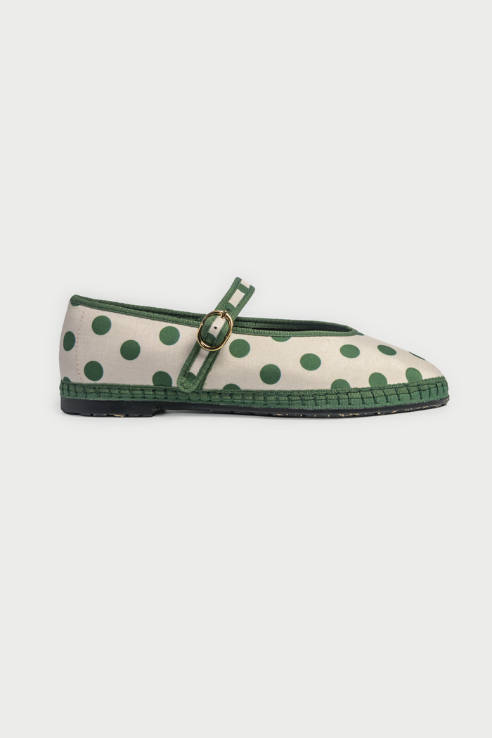 The FLABELUS Polka Dot Pierre is a cream Mary Jane flat with green polka dots, a green sole, and a green strap with a gold buckle, shown side view on a plain white background.