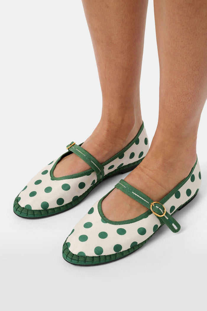The FLABELUS Polka Dot Pierre is a cream Mary Jane flat with green polka dots, a green sole, and a green strap with a gold buckle, shown side view on a plain white background.