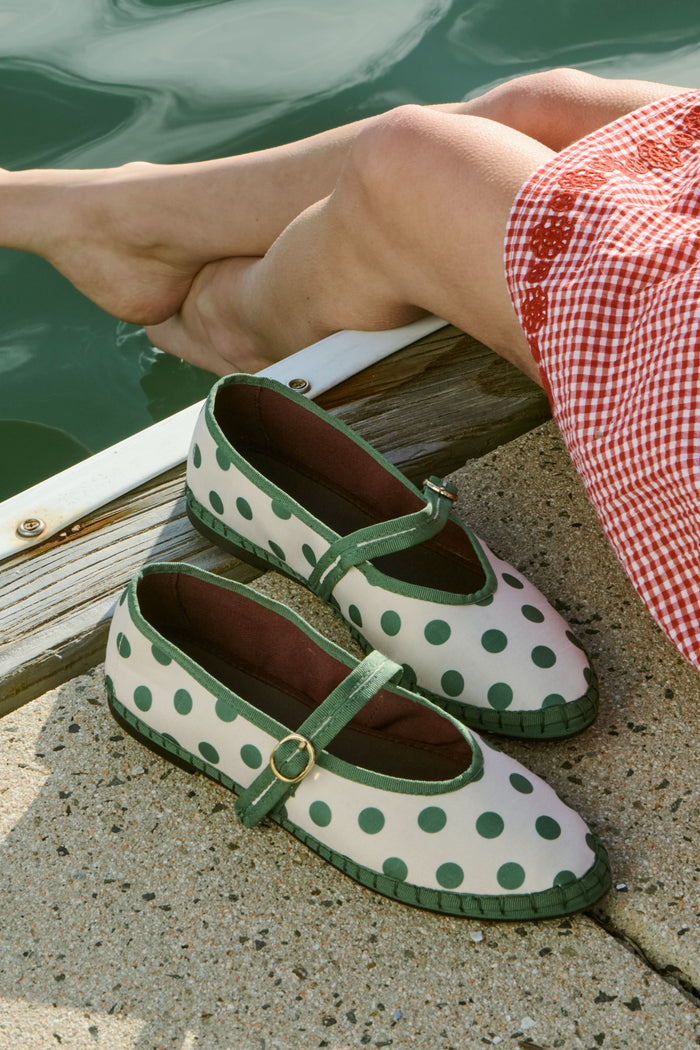 The FLABELUS Polka Dot Pierre is a cream Mary Jane flat with green polka dots, a green sole, and a green strap with a gold buckle, shown side view on a plain white background.