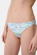 A person wears the Roller Rabbit Regatta Marais Bikini Bottom, featuring a colorful nautical print with boats and lighthouses. The UPF 50+ swimwear offers sun protection. Image is cropped from chest to upper thighs.