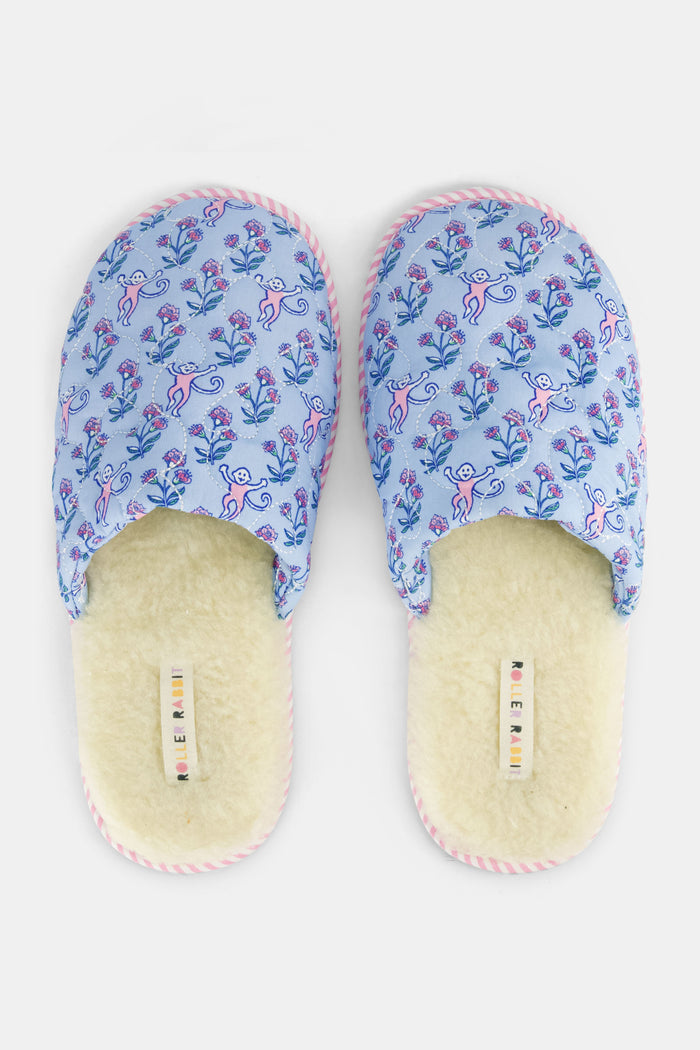 The Rosa Ditsy Monkey Quilted Slippers by Roller Rabbit feature a blue floral pattern, pink striped soles, and faux-shearling lining, displayed side by side on a white background.