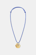 The Roller Rabbit Seashell Cord Necklace features a blue and white braided adjustable cord with a gold shell pendant, shown on a plain white background.
