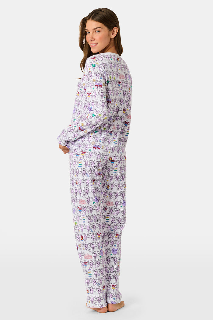 The Sigma Kappa Monkey Pajamas by Roller Rabbit is a long-sleeve set featuring a buttoned top and comfortable elastic waist, decorated with an all-over pattern of colorful cartoon monkey faces on a white background.