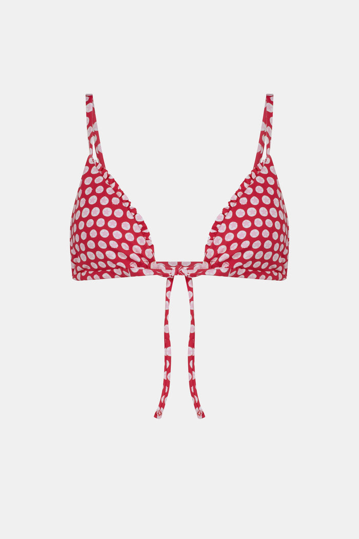 A woman wears the Roller Rabbit Starry Dot Isa Bikini Top, a red triangle bikini with white polka dots and a front tie, shown from shoulders to waist against a plain background.