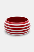 The Roller Rabbit Striped Bangle is a wide, round wooden bracelet with a glossy red finish and evenly spaced hand-painted white stripes, shown on a plain light gray background.