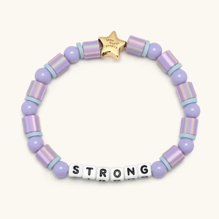 Lavender beaded bracelet with a gold star tag and letter beads spelling 'STRONG' on a white background