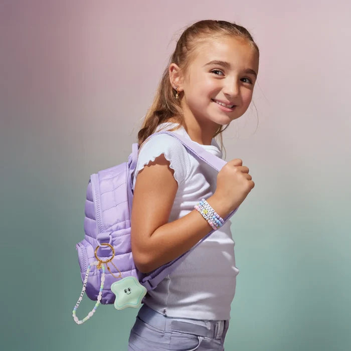 Young girl with a purple backpack against a gradient background